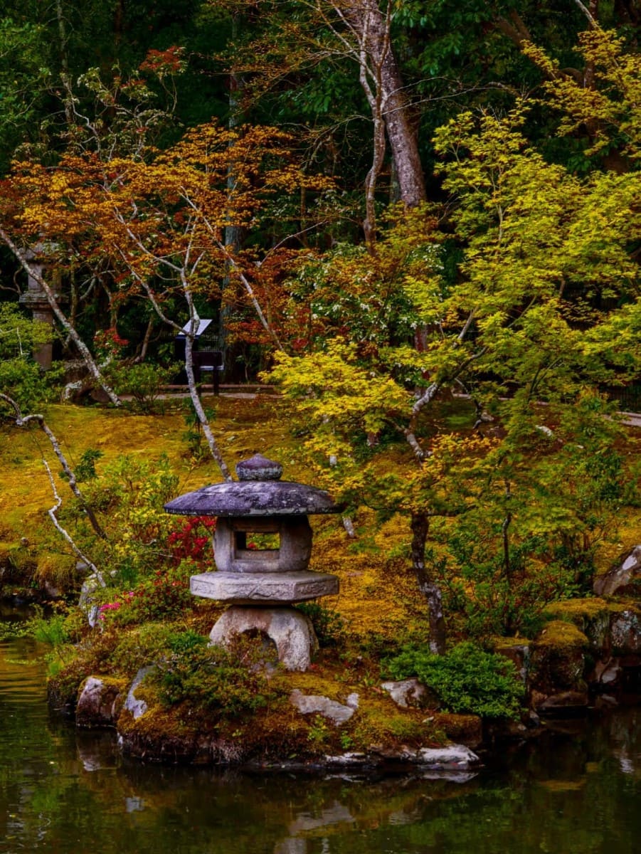 Japanische Gartenanlage mit einem Steintempel dire direkt am See